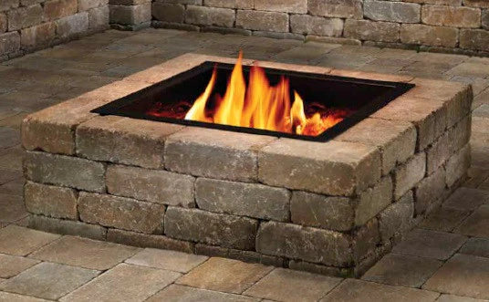 Stone fire pit with flames on a patio