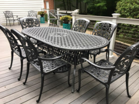 Outdoor patio set with a round table and chairs on a wooden deck.